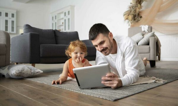 Padre mostrando contenido de un iPad a su hija